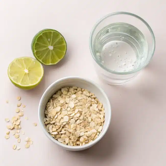  Ingredients for Oatzempic diet drink: ½ cup rolled oats, 1 cup water, and juice of ½ lime arranged on a countertop.